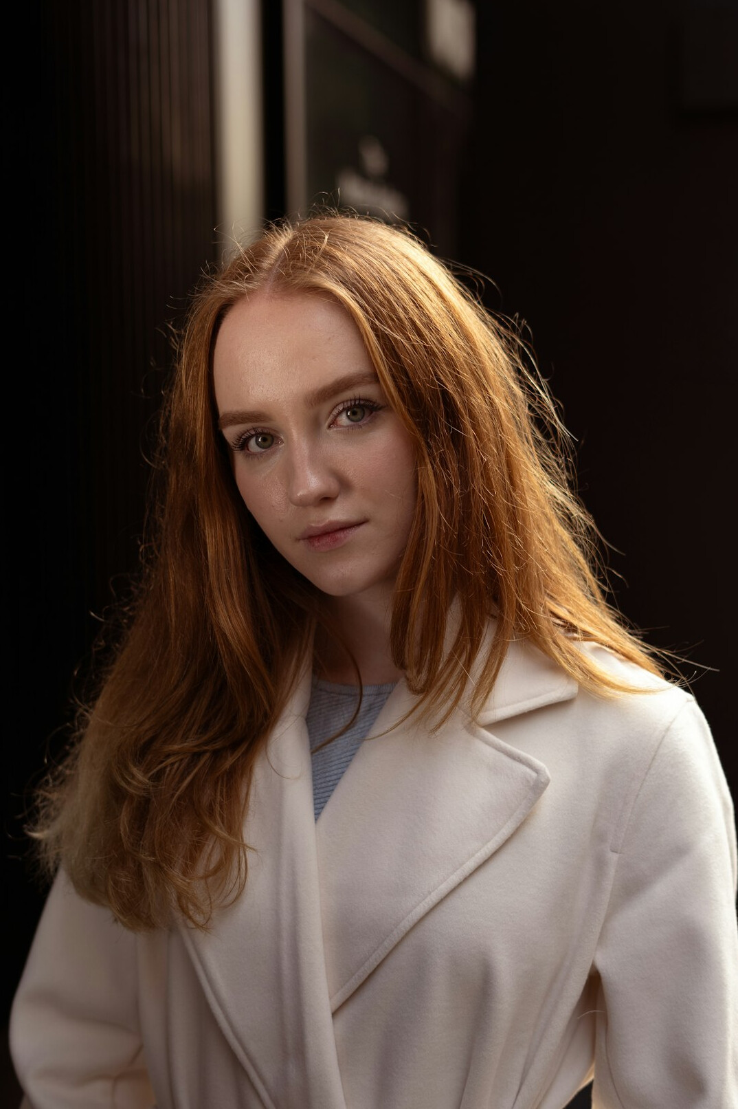 Portrait of a woman with auburn hair wearing a white coat